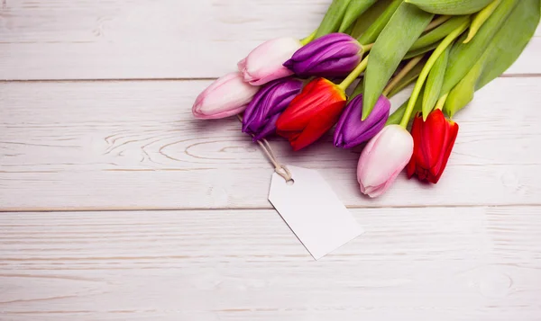 Manojo de tulipanes y tarjeta blanca — Foto de Stock