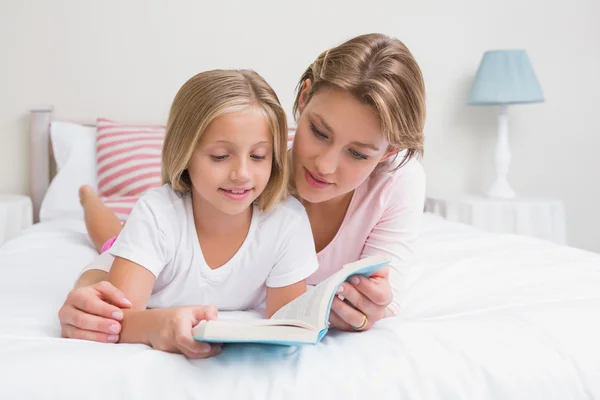 母亲和女儿读本书一起在床上 — 图库照片