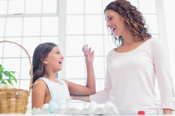 Happy girl showing easter egg to her mother — Stock Photo, Image