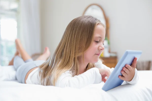 Bambina utilizzando tablet pc nel letto — Foto Stock