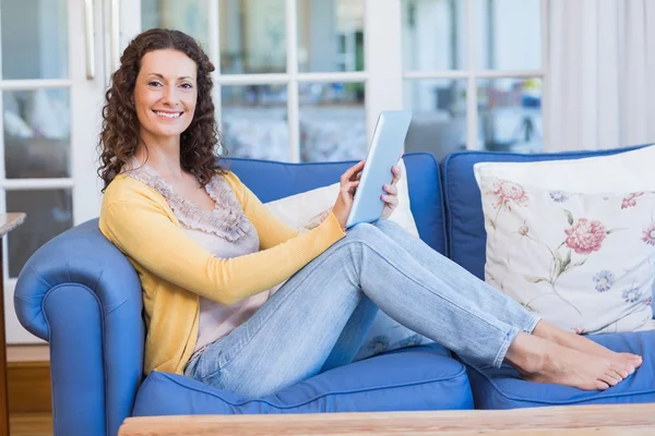 Brünette entspannt auf der Couch mit Tablet — Stockfoto