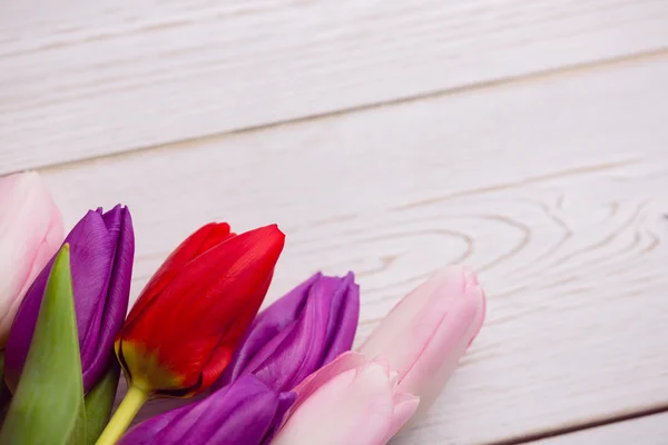 Ramo de tulipanes sobre mesa de madera — Foto de Stock