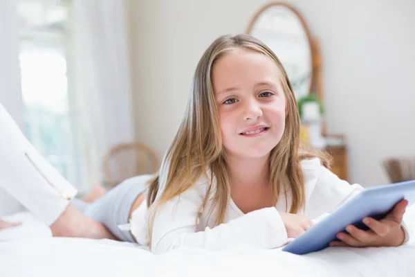 Liten flicka med hjälp av TabletPC i sängen — Stockfoto