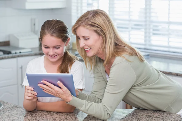 Mãe feliz e filha usando tablet pc juntos — Fotografia de Stock