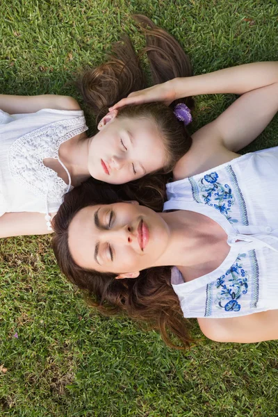 Madre e hija acostadas en la hierba — Foto de Stock