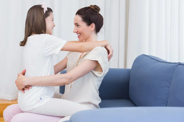 Moeder en dochter glimlachen bij elkaar — Stockfoto