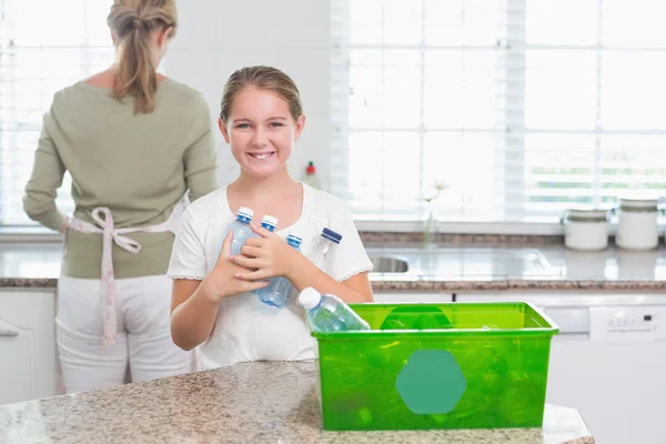 Menina feliz segurando garrafas de reciclagem — Fotografia de Stock