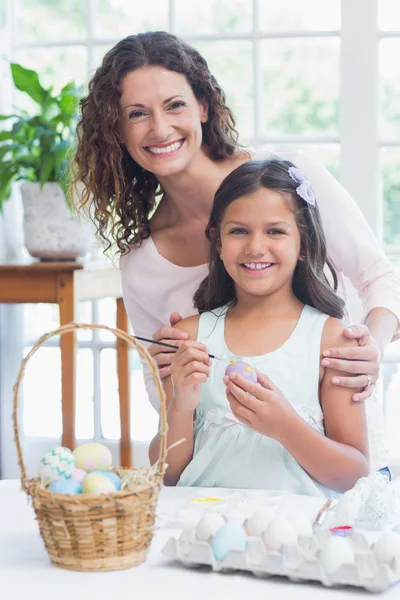 Mãe feliz e filha pintando ovos de Páscoa — Fotografia de Stock