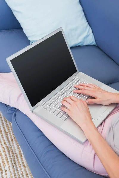 Casual woman using laptop on couch — Stock Photo, Image