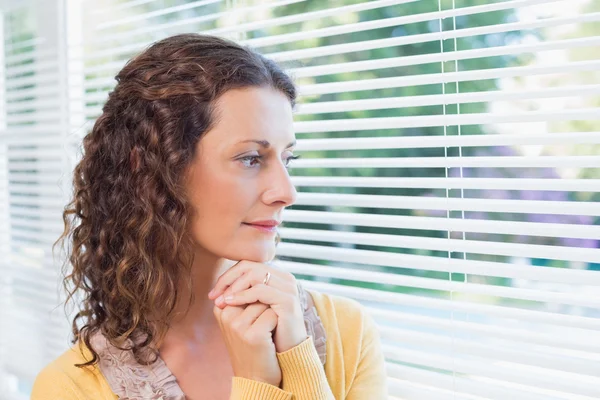 Mooie brunette permanente door het venster — Stockfoto