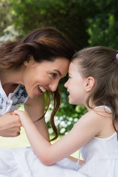 Moeder en dochter glimlachen bij elkaar — Stockfoto