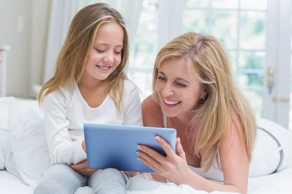 Madre e hija usando tableta pc en la cama —  Fotos de Stock