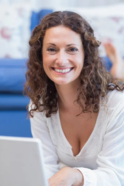 Vrouw op de vloer liggen en met behulp van laptop — Stockfoto