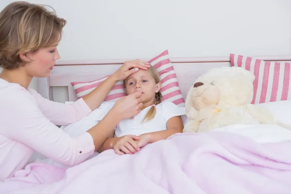 Mamma tar temperaturen av sjuka dotter — Stockfoto