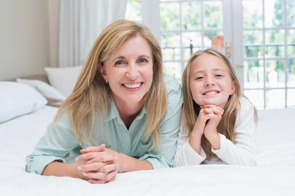Happy mother and daughter smiling at camera — Stock Photo, Image