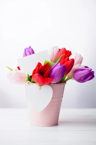 Bunch of tulips and white card — Stock Photo, Image