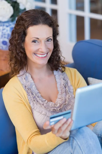 Brünette entspannt auf der Couch mit Tablet — Stockfoto