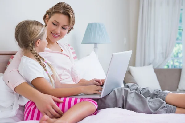 Mor och dotter med laptop i sängen — Stockfoto