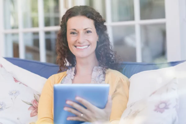 Morena relaxante no sofá com tablet — Fotografia de Stock