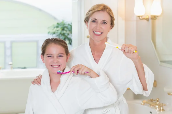 Счастливые мать и дочь чистят зубы вместе — стоковое фото