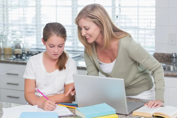 Glad mamma att hjälpa dotter gör läxor — Stockfoto