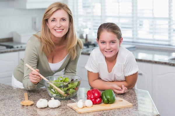 Happy mother and daughter preparing salad together — Stock Photo, Image