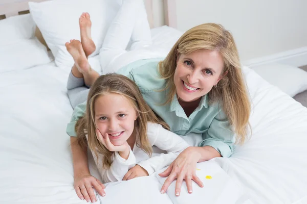 Mãe e filha felizes lendo um livro — Fotografia de Stock