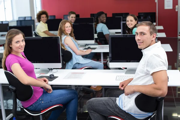 Usmívající se studenti v počítačové učebně — Stock fotografie