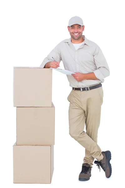 Delivery man leaning on cardboard boxes — Stock Photo, Image