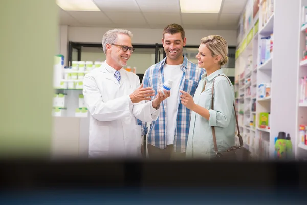 Farmacêutico e clientes falando sobre medicação — Fotografia de Stock