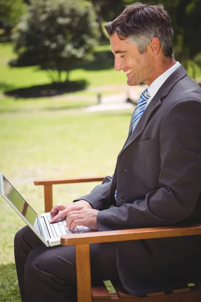 Uomo d'affari che utilizza il computer portatile nel parco — Foto Stock