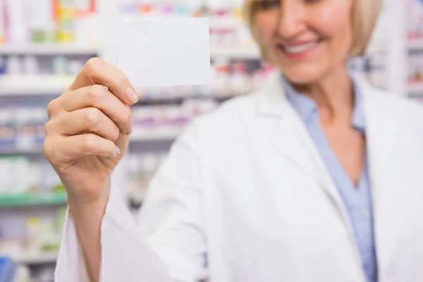 Smiling pharmacist showing calling card — Stock Photo, Image