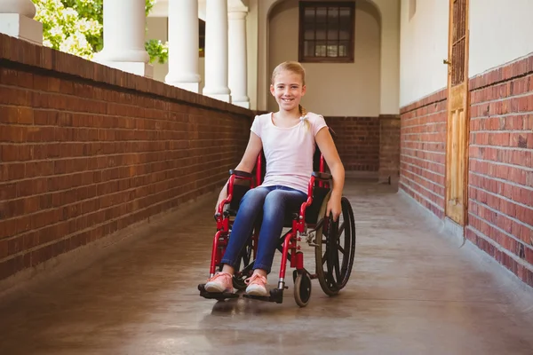 Дівчина сидить у інвалідному візку в шкільному коридорі — стокове фото