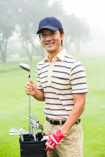 Happy golfer taking club from golf bag — Stock Photo, Image