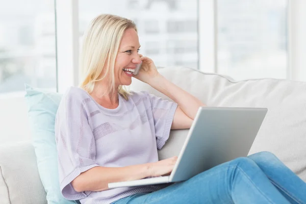 Femme parlant au téléphone en utilisant un ordinateur portable — Photo