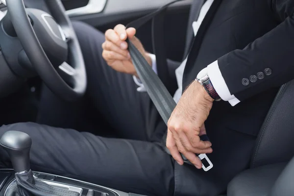 Businessman putting on his seat belt — Stock Photo, Image