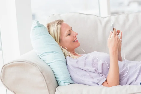 Mujer escuchando música mientras miente —  Fotos de Stock