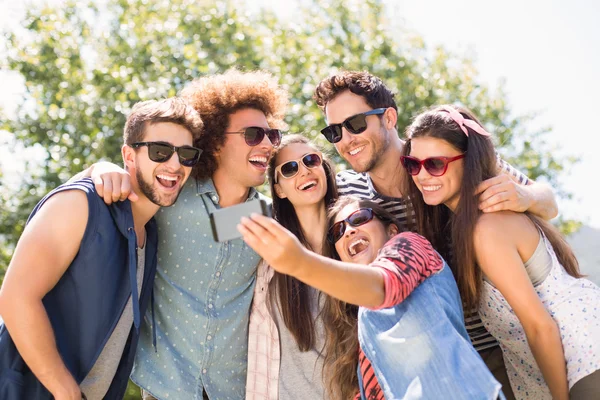 Amici felici nel parco prendendo selfie — Foto Stock