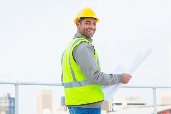 Architect in beschermende kleding bedrijf blauwdruk — Stockfoto