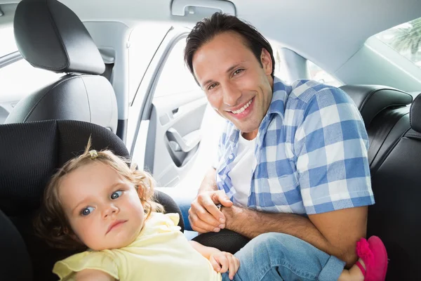 Ojciec zabezpieczanie swojego dziecka w foteliku samochodowym — Zdjęcie stockowe