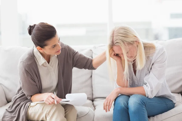 Terapeut tröstande upprörd kvinna på soffa — Stockfoto