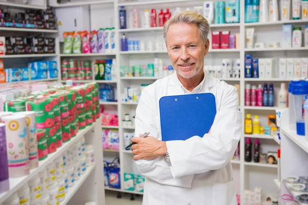 Farmacêutico sénior segurando uma área de transferência — Fotografia de Stock