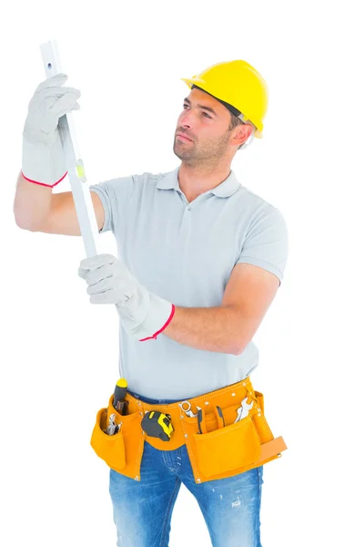 Handyman examining spirit level — Stock Photo, Image