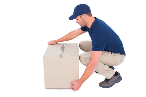 Delivery man picking cardboard box — Stock Photo, Image