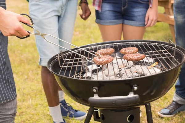 Amigos felizes no parque fazendo churrasco — Fotografia de Stock