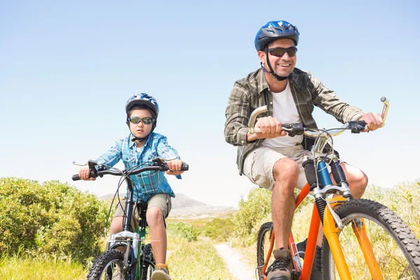 Pai e filho de bicicleta através das montanhas — Fotografia de Stock