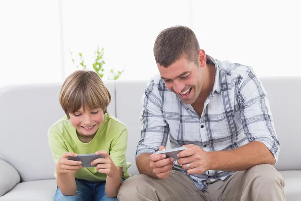 Vader en zoon spelen op mobiele telefoon — Stockfoto