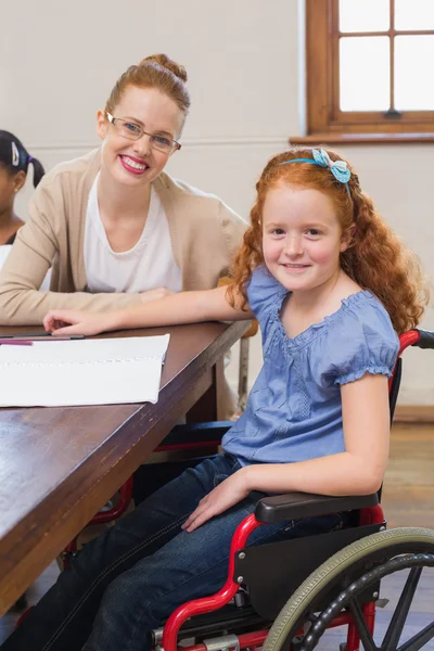 Schöne Lehrerin hilft Schülerin im Klassenzimmer — Stockfoto