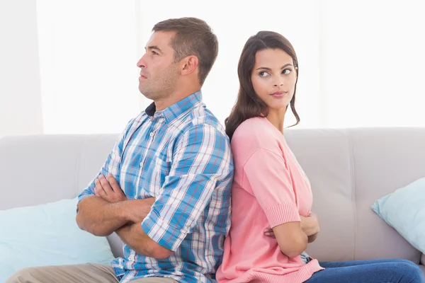 Mujer mirando al hombre sentado en el sofá — Foto de Stock