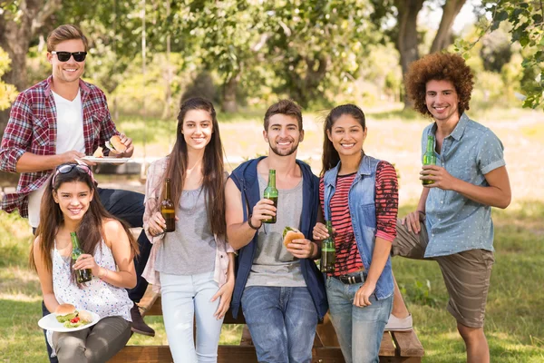 Felices amigos en el parque teniendo barbacoa —  Fotos de Stock